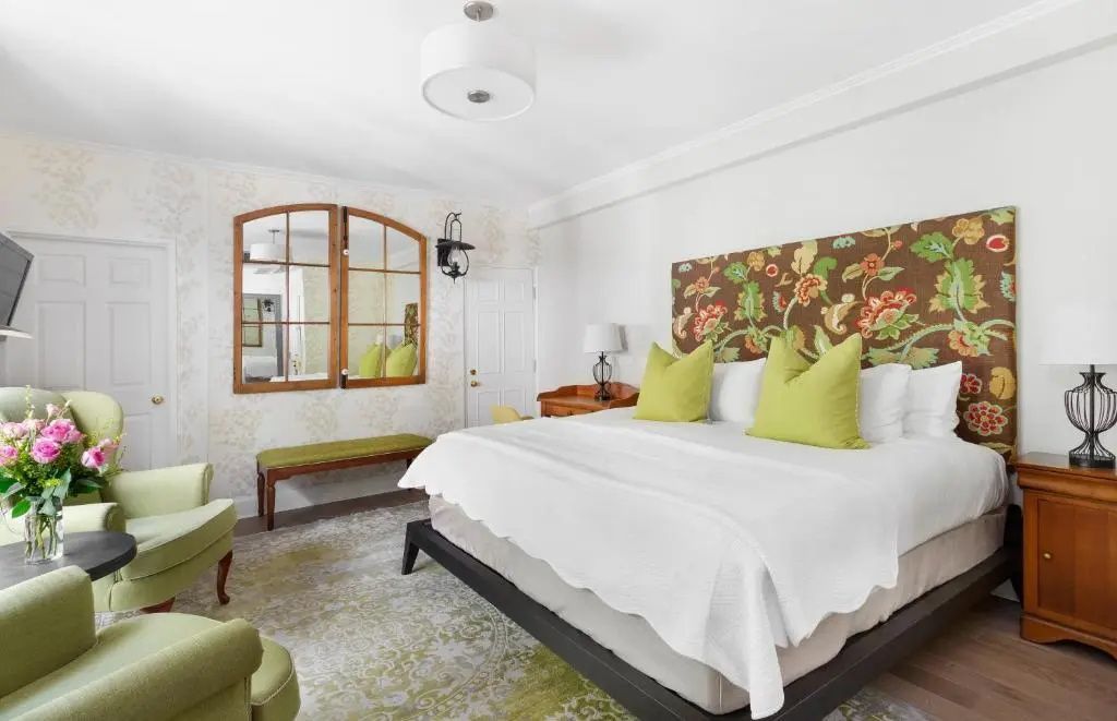 Doppelzimmer mit stilvollem Blumenmotiv über dem Bett und viel natürlichem Licht