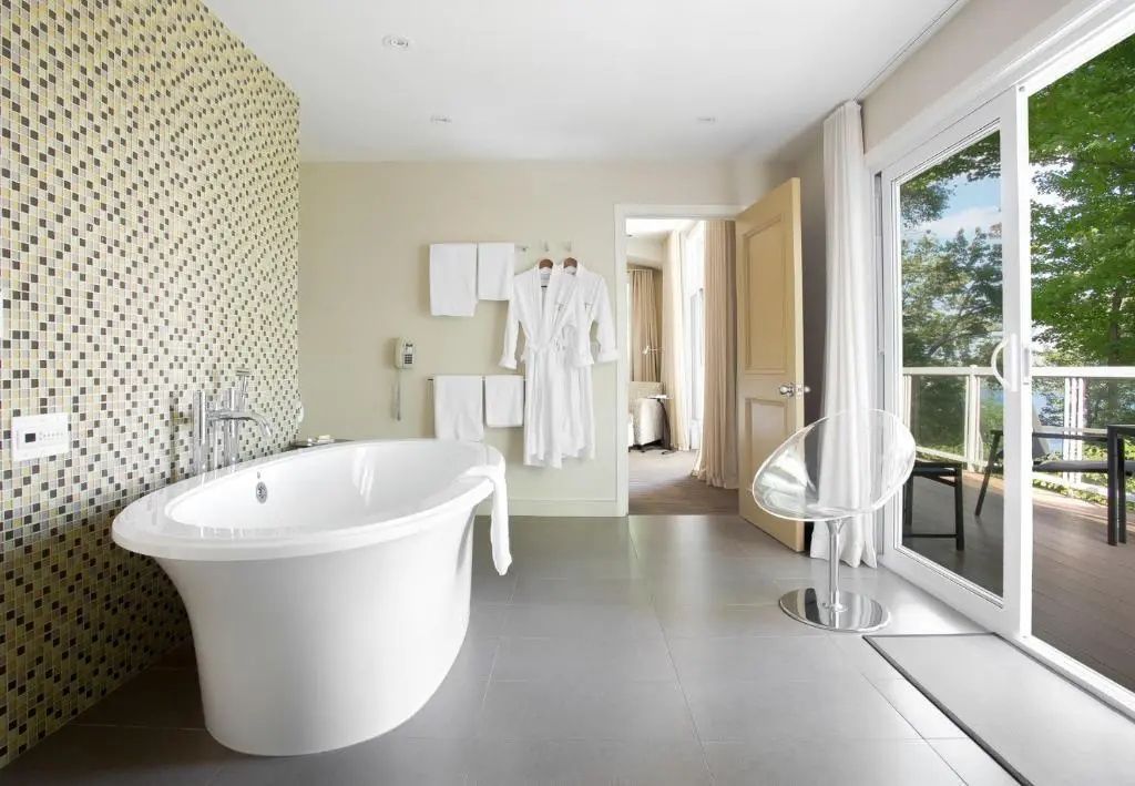 Modernes Badezimmer mit freistehender Badewanne und weichen Bademänteln