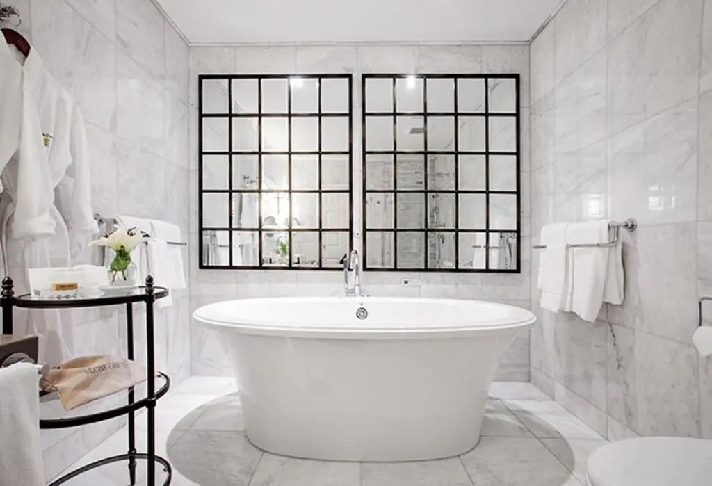 Geräumiges Badezimmer in Marmoroptik mit eleganter Badewanne