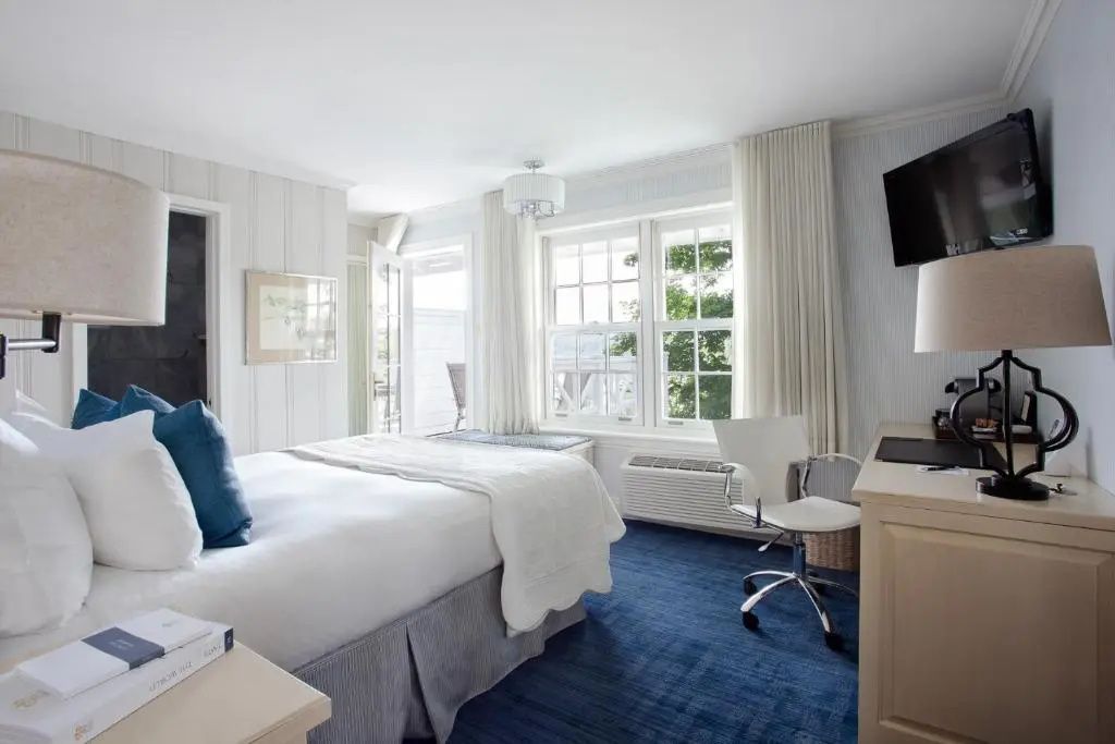 Hell und modern eingerichtetes Superior Zimmer mit großem Fenster und stilvollem Mobiliar