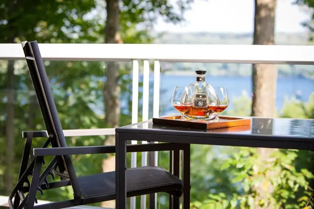 Sitzecke mit Blick auf den See und einer Flasche edlem Cognac auf dem Tisch