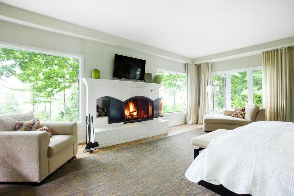 Gemütlicher Kamin in einem eleganten Wohnzimmer mit grüner Aussicht
