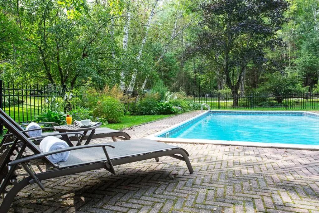 Entspannungsbereich mit Liegestühlen am Pool im grünen Garten