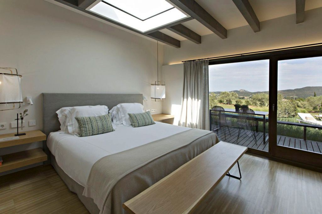 Elegantes Schlafzimmer mit großem Fenster und Blick auf die Natur