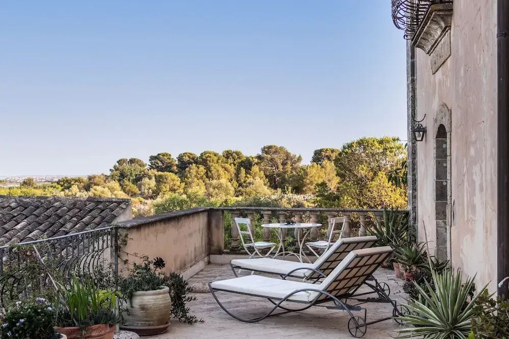Geräumige Terrasse mit Panoramablick auf grüne Landschaft und eleganter Möblierung.