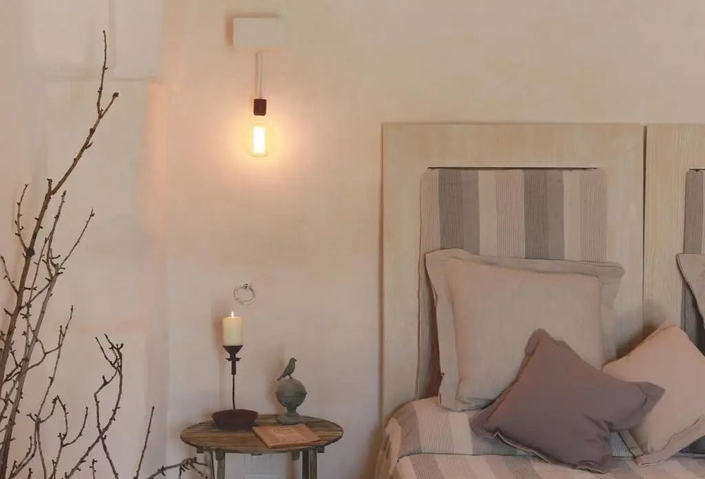 Gemütliche Nachttischlampe neben einem stilvollen Bett.