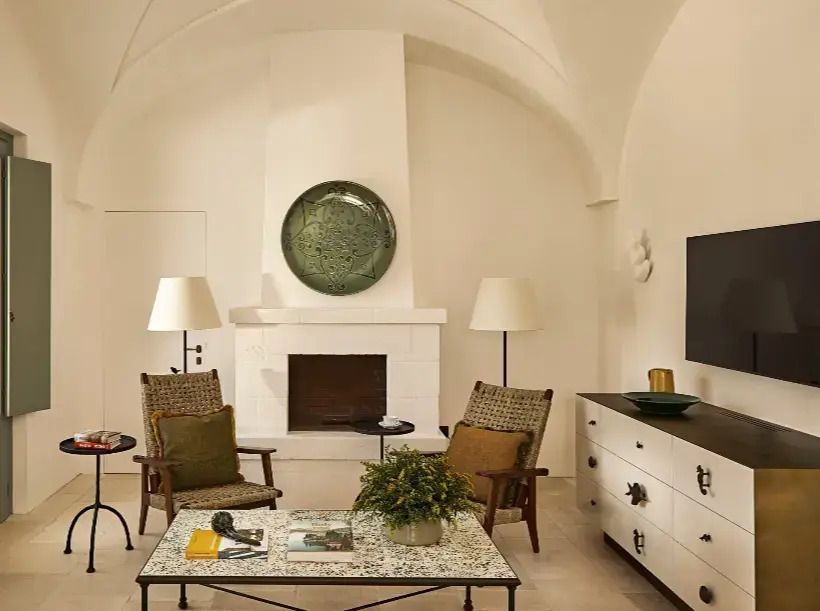 Eleganter Wohnbereich mit Kamin und stilvollen Möbeln in der Degli Ulivi Borgo Suite.