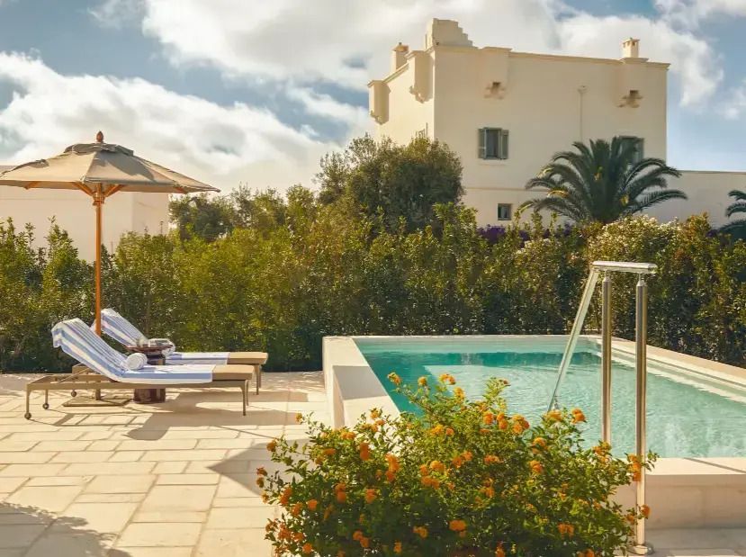 Privater Poolbereich mit Liegestühlen und mediterraner Pflanzenkulisse im Hotel Rocco Forte Masseria Torre Maizza.