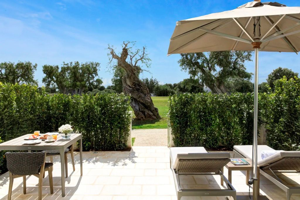 Private Terrasse mit Liegestühlen und Blick auf einen gepflegten Garten