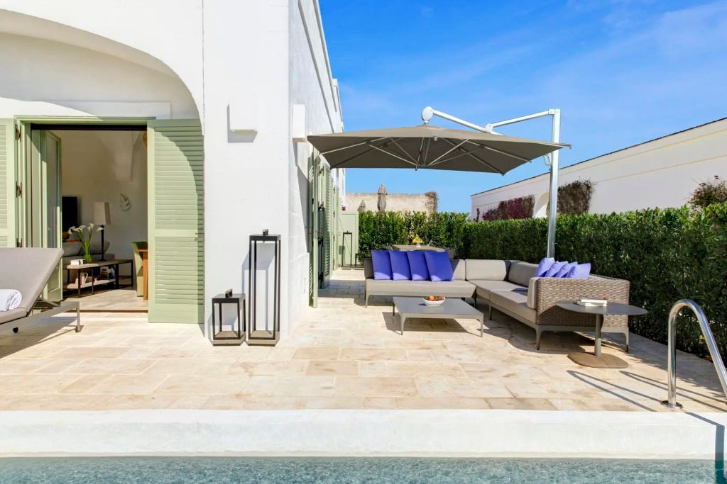 Terrasse mit komfortabler Sitzgruppe und Sonnenschirm neben privatem Pool