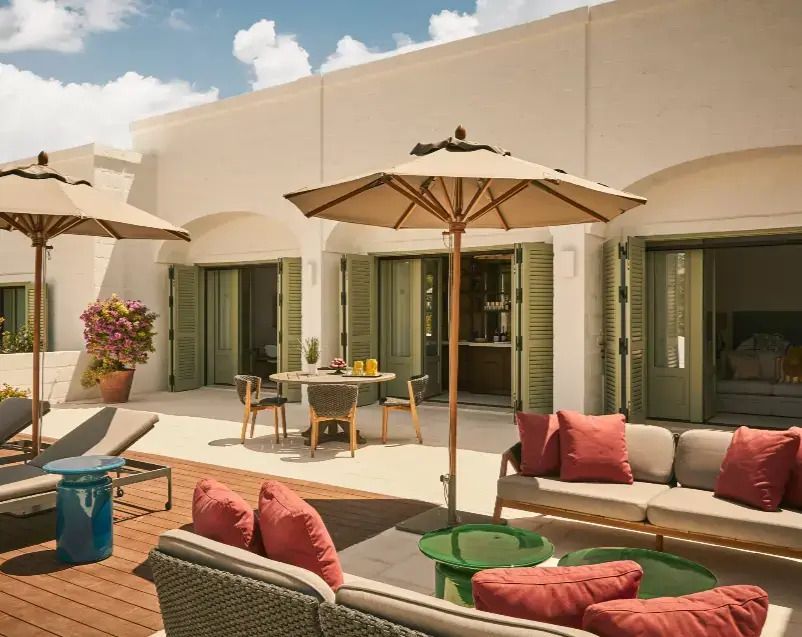 Terrasse mit Lounge-Möbeln und Sonnenschirmen vor der Suite