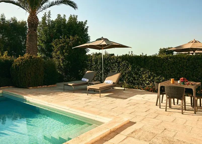 Private Gartenterrasse mit Pool, Liegestühlen und Sonnenschirm