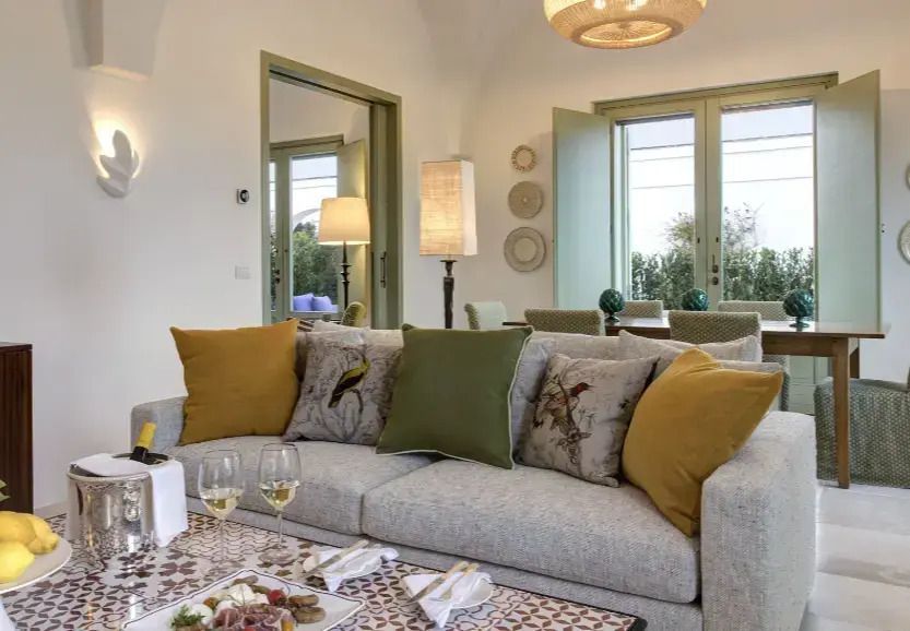 Geschmackvoll gestalteter Wohnbereich mit Sofa, dekorativen Kissen und Naturlicht