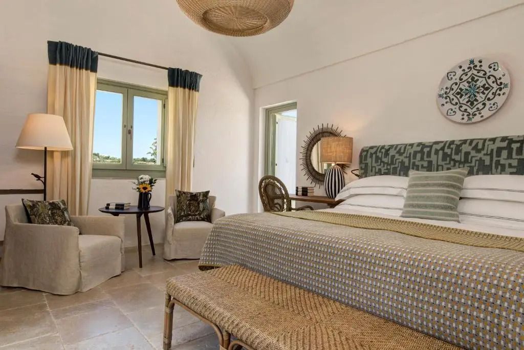 Helles Superior Doppelzimmer mit eleganter Einrichtung und großem Fenster mit Vorhängen.