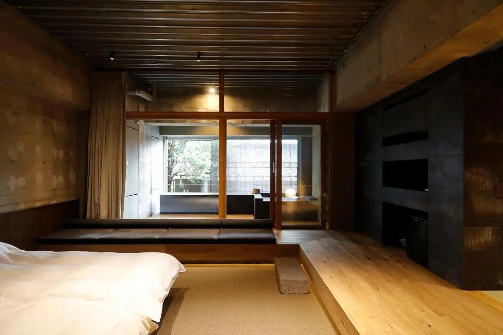 Moderne Junior-Suite mit Holz- und Betonelementen und großzügigem Fensterbereich.