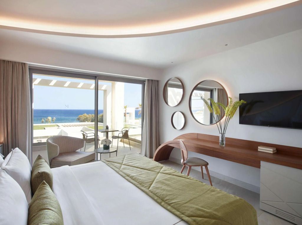 Helles Zimmer mit Meerblick, modernem Schreibtisch und dekorativen Spiegeln