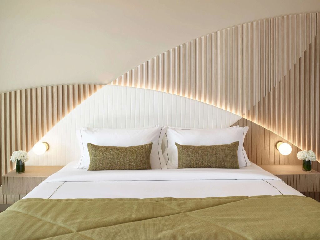 Luxuriöses Doppelbett mit eleganten grünen Akzenten und modernem Kunstwanddesign