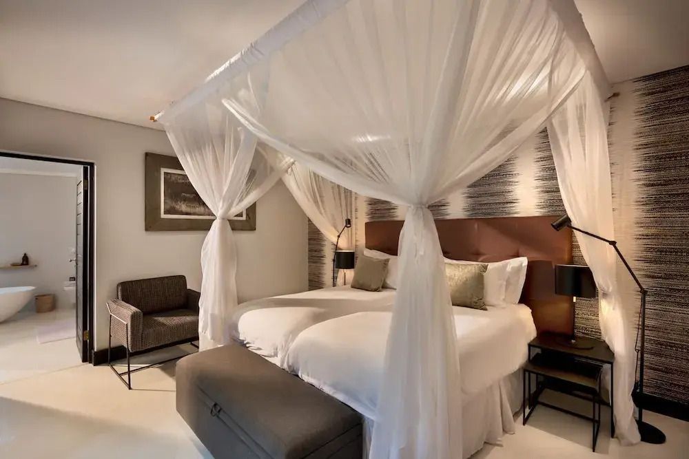 Schlafzimmer mit Doppelbett und Baldachin sowie moderner Dekoration