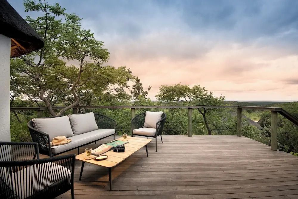 Terrasse mit Sitzgelegenheiten und Blick auf die Landschaft bei Sonnenuntergang