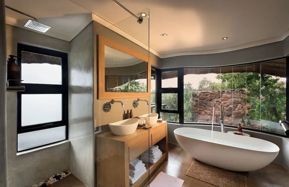 Modernes Badezimmer mit freistehender Badewanne und Blick in die Natur
