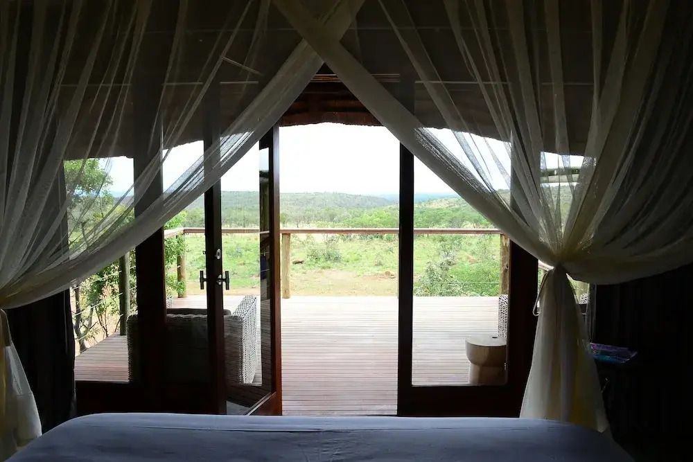 Sicht auf die Landschaft von einem Schlafzimmer mit fließenden Vorhängen