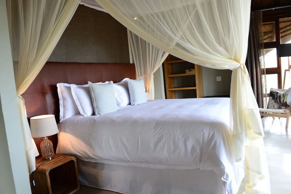 Elegantes Doppelbett mit Baldachin und Kissen im luxuriösen Zimmer