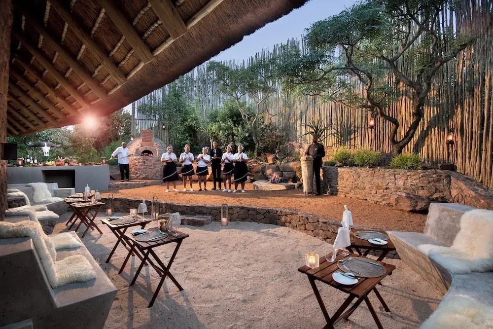 Outdoor-Essbereich mit Personal und Grill in rustikaler Umgebung