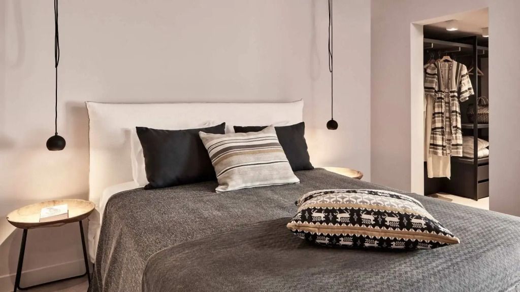 Gemütliches Doppelbett mit eleganten Zierkissen in neutralen Tönen