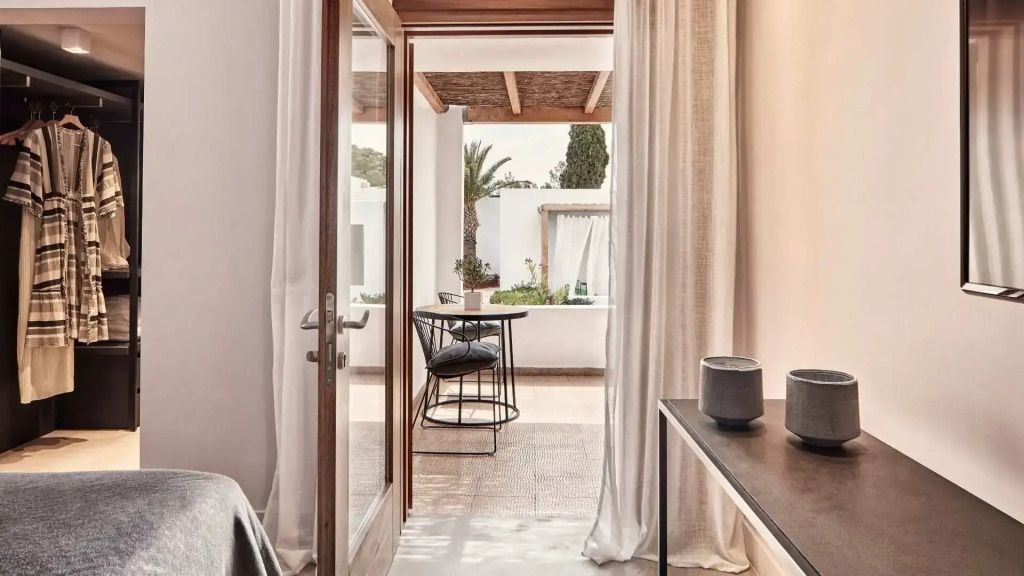 Ausblick von einem Zimmer auf Terrasse mit Pflanzen und Sitzbereich