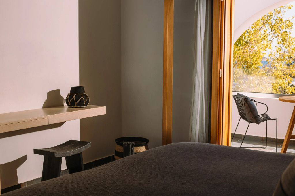 Zimmer mit Holzmöbeln und Zugang zu einem Balkon