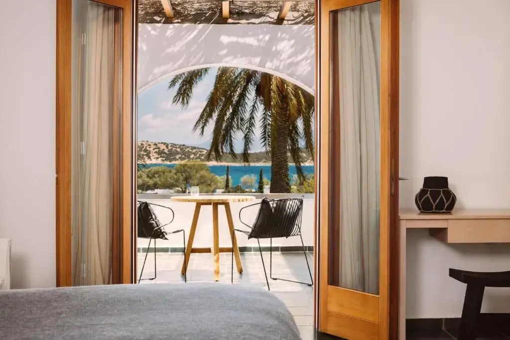Balkon mit Meerblick und Palmen durch Glastüren vom Zimmer aus