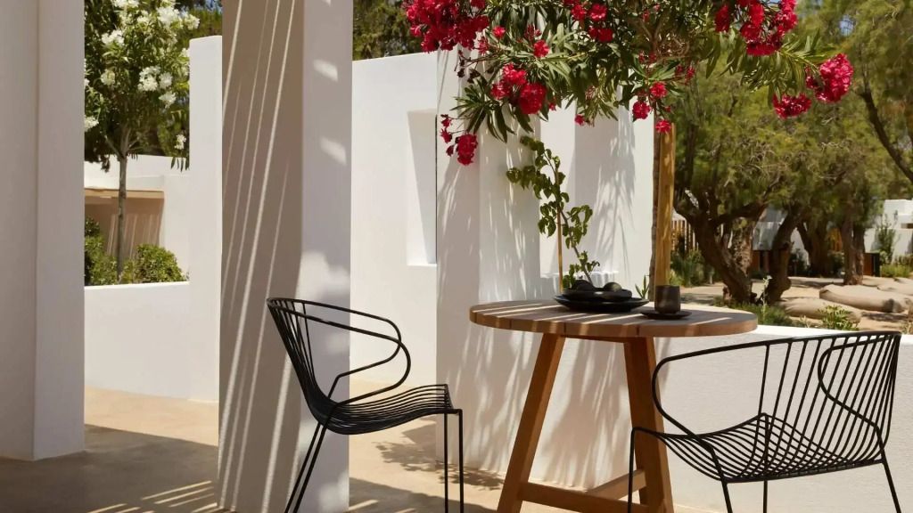 Idyllische Terrasse mit Tisch, Stühlen und blühenden Pflanzen