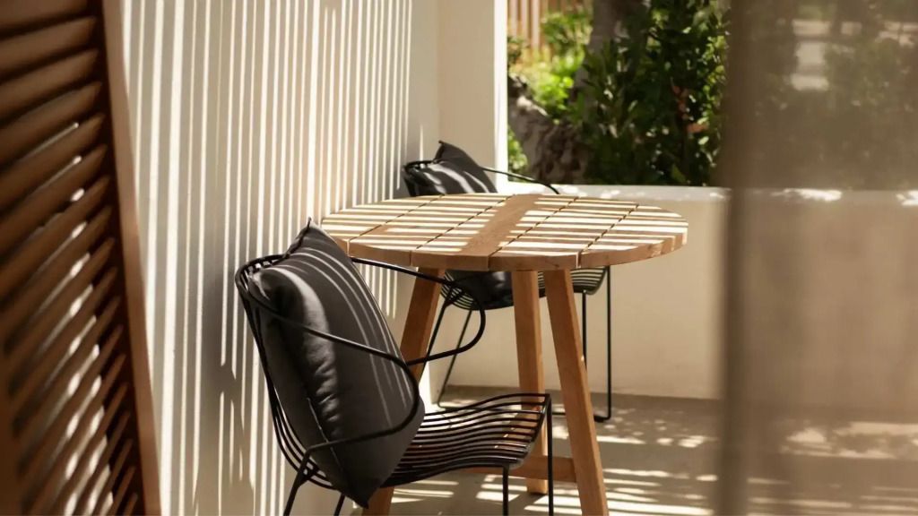 Private Terrasse mit Holztisch und gemütlichen Stühlen im Minos Beach Art Hotel.