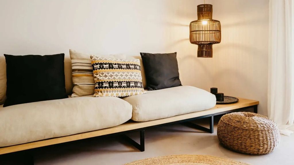 Gemütliches Sofa mit dekorativen Kissen und stimmungsvollem Lampenlicht im Wohnzimmer