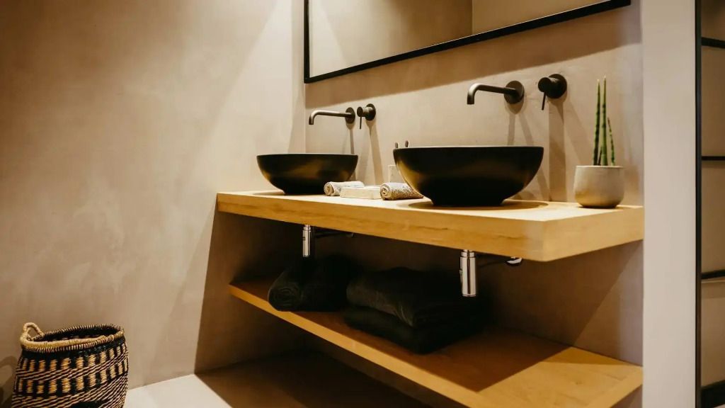 Modernes Badezimmer mit zwei Waschbecken auf Holztheke und luxuriösen Armaturen