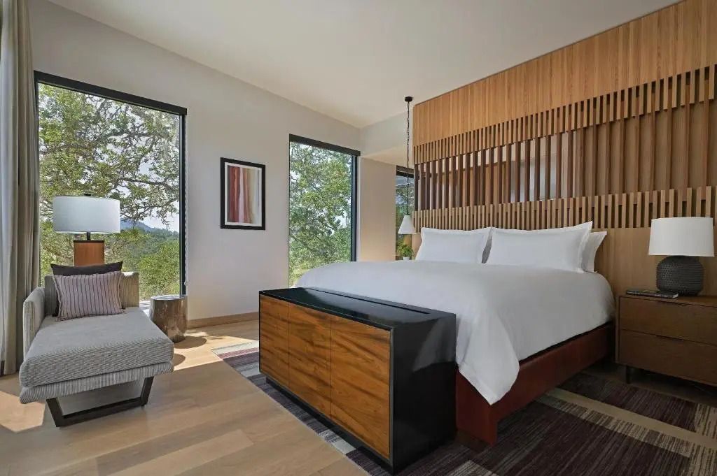 Geräumiges Schlafzimmer mit Designer-Bett und großen Fenstern