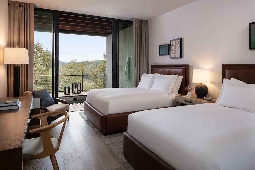 Zweibettzimmer mit großem Fenster und Balkonblick auf die Natur