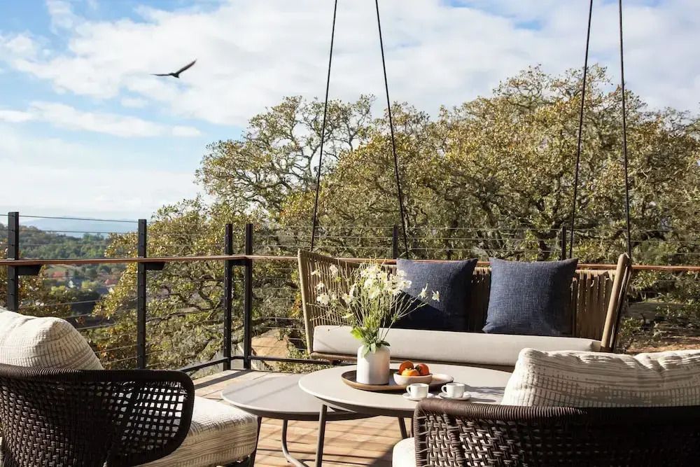 Gemütliche Terrasse mit Sitzmöbeln und Ausblick auf Eichenbäume