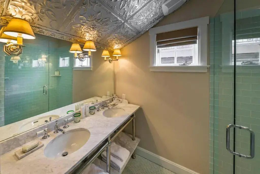 Modernes Badezimmer mit Doppelwaschbecken Marmortheke und dekorativen Wandleuchten