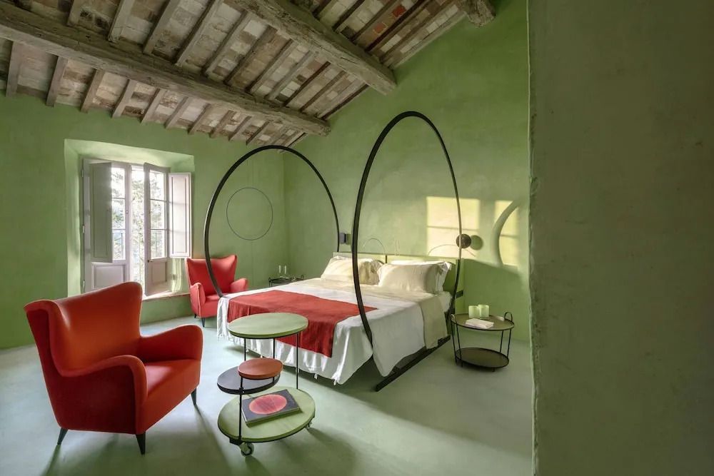 Helles Zimmer in grün mit Designerbett und roten Akzenten