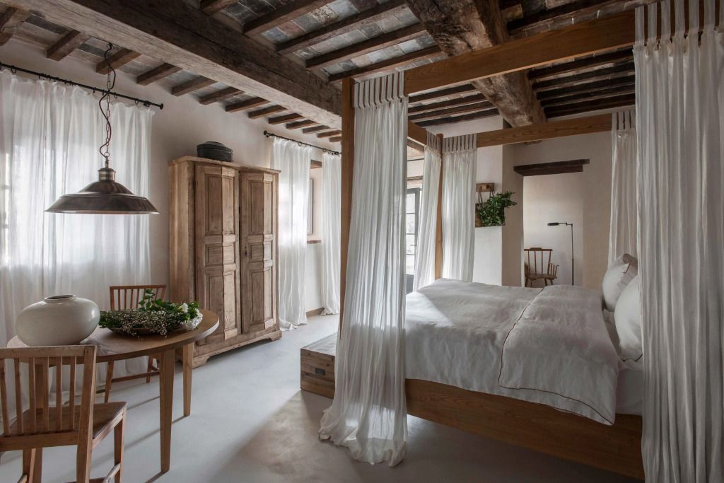 Rustikales Schlafzimmer mit Holzbalkendecke und Himmelbett in neutralen Tönen