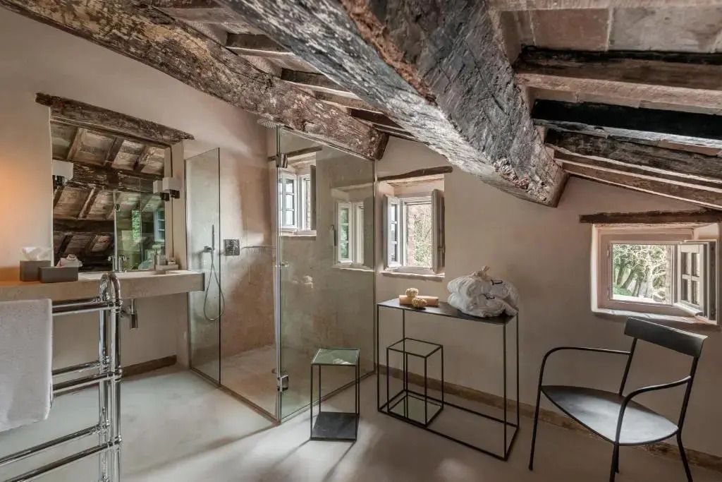 Modernes Badezimmer mit Glasdusche und rustikalen Holzbalken