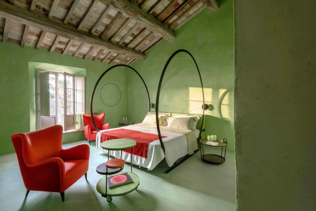Grüne Suite mit Himmelbett und roten Akzentmöbeln