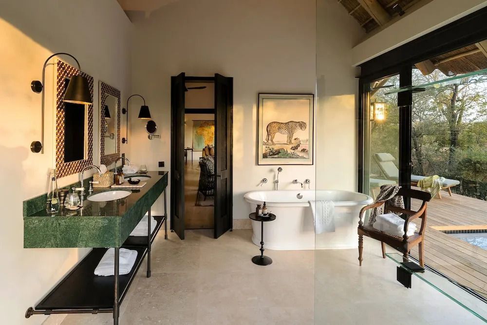 Luxuriöses Badezimmer mit freistehender Badewanne und großen Fenstern im Monwana Hotel