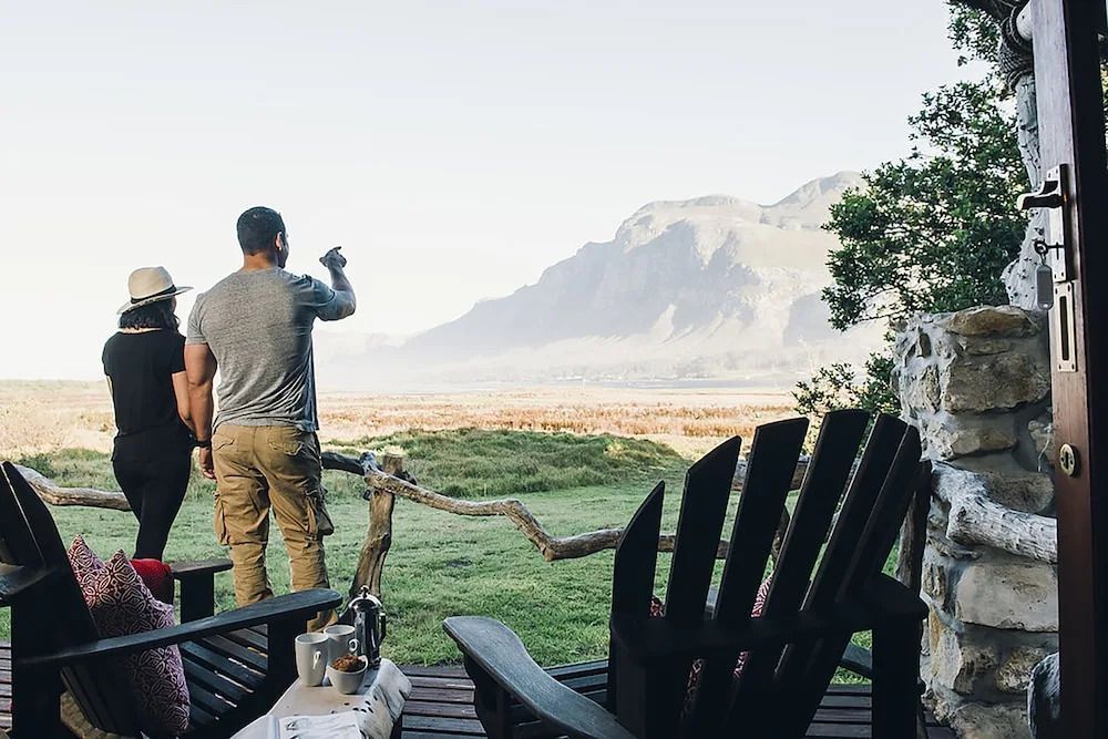 Personen genießen den Panorama-Blick auf die Berge von der Terrasse