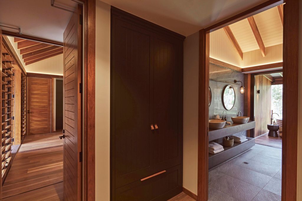 Moderner Eingangsbereich zum Badezimmer mit Holzdetails und runder Spiegel