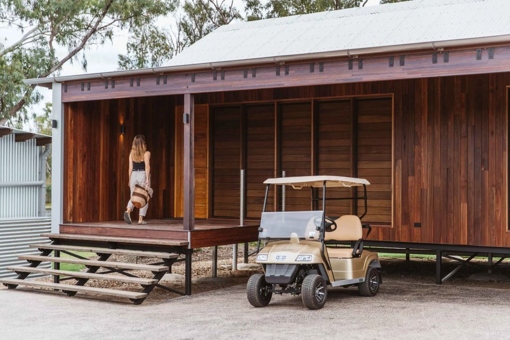 Eingang einer Lodge mit Holzverkleidung und Golfcart auf der Veranda