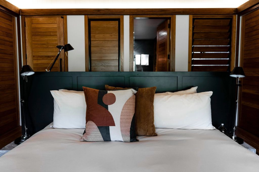 Bett mit künstlerisch dekorierten Kissen in einer Suite