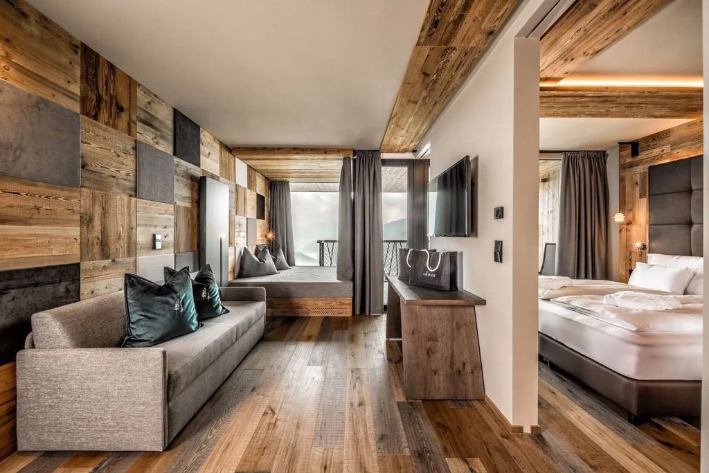 Moderne Suite mit Holzwänden und eleganter Einrichtung, zwei Doppelbetten.