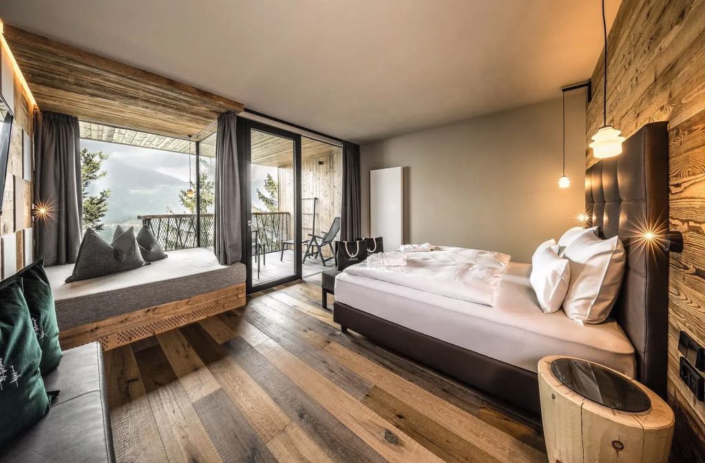 Geräumiges Hotelzimmer mit Doppelbett und großem Fenster mit Blick ins Grüne